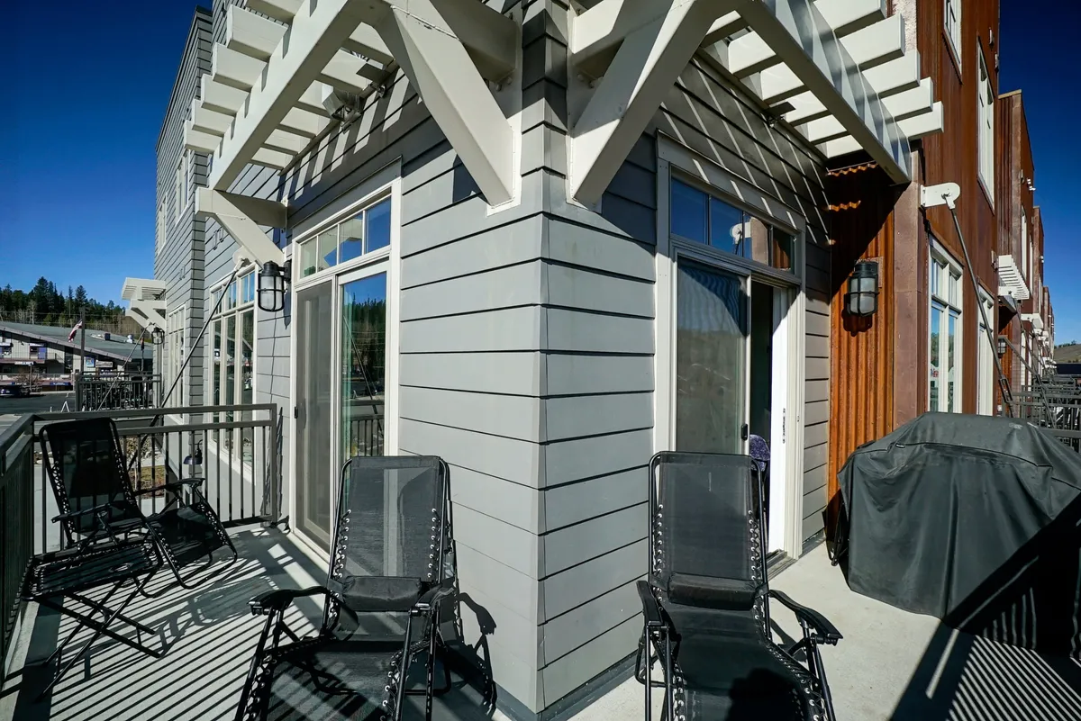 An outdoor wraparound deck with comfortable balcony seating, a built-in gas grill, and architectural detailing. The space is perfect for enjoying sunset dinners, morning coffee, and gatherings with friends, all while taking in the mountain air.