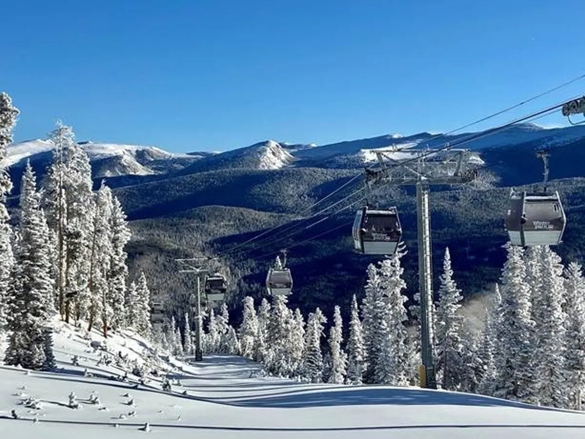 An exciting exterior winter scene showing a gondola lift moving up snow-covered slopes bordered by pine trees and majestic mountains. The area is ready for skiing, snowboarding, and scenic rides, with a sense of adventure and energy.